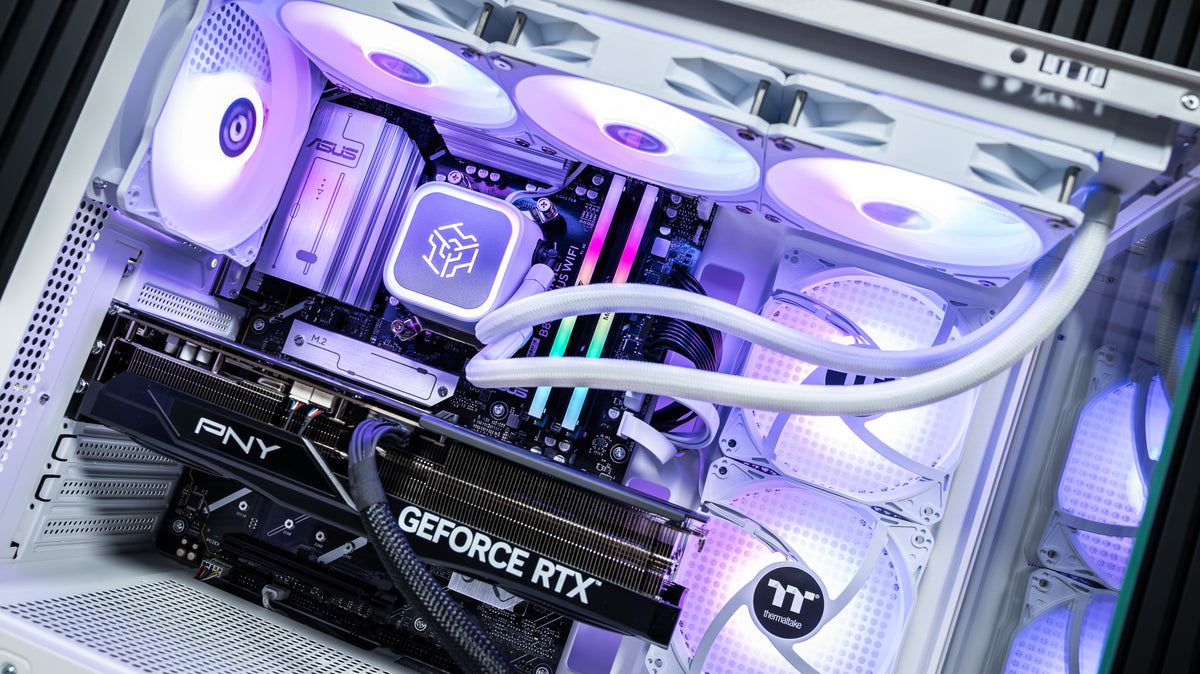 Close-up inside the Snow Hawk PC showing white 360mm liquid cooler, RGB DDR5 RAM and PNY GeForce RTX 5070 Ti with purple lighting